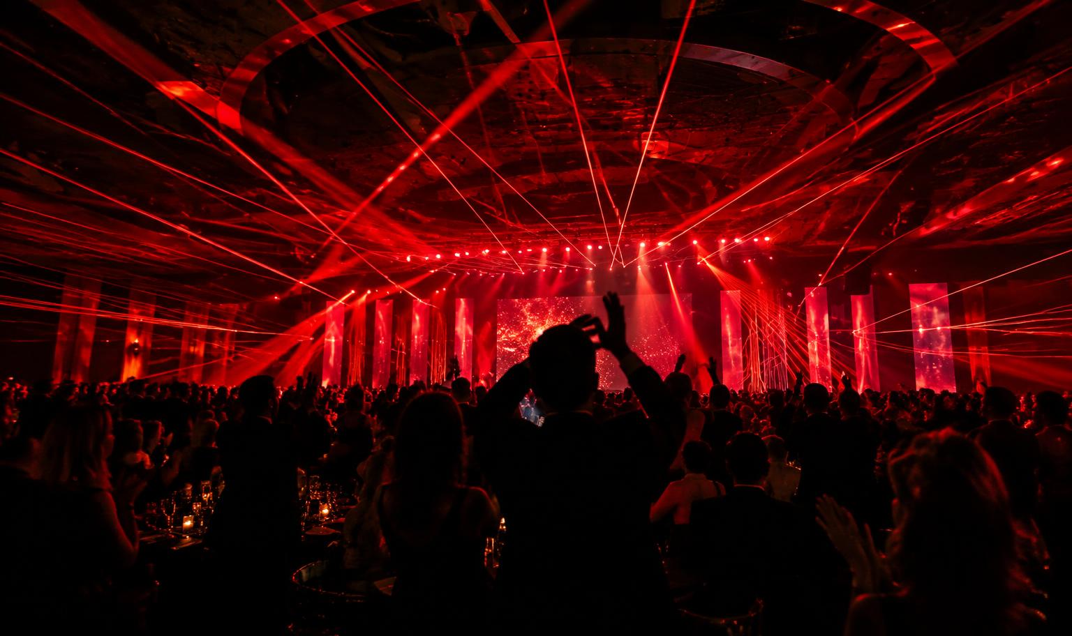 Audience under vivid red light at an awards show